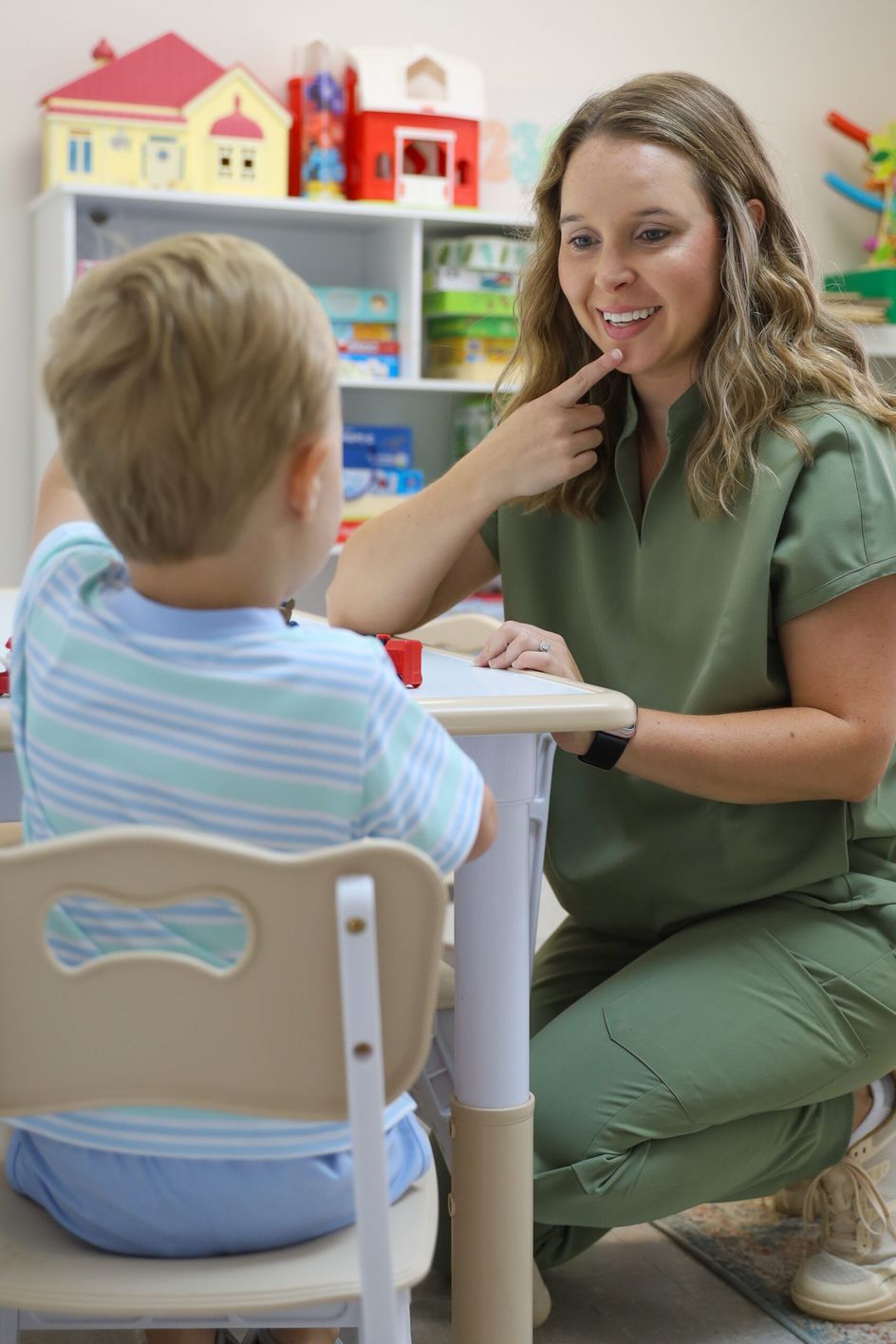 Hayley working with a young boy at a play table